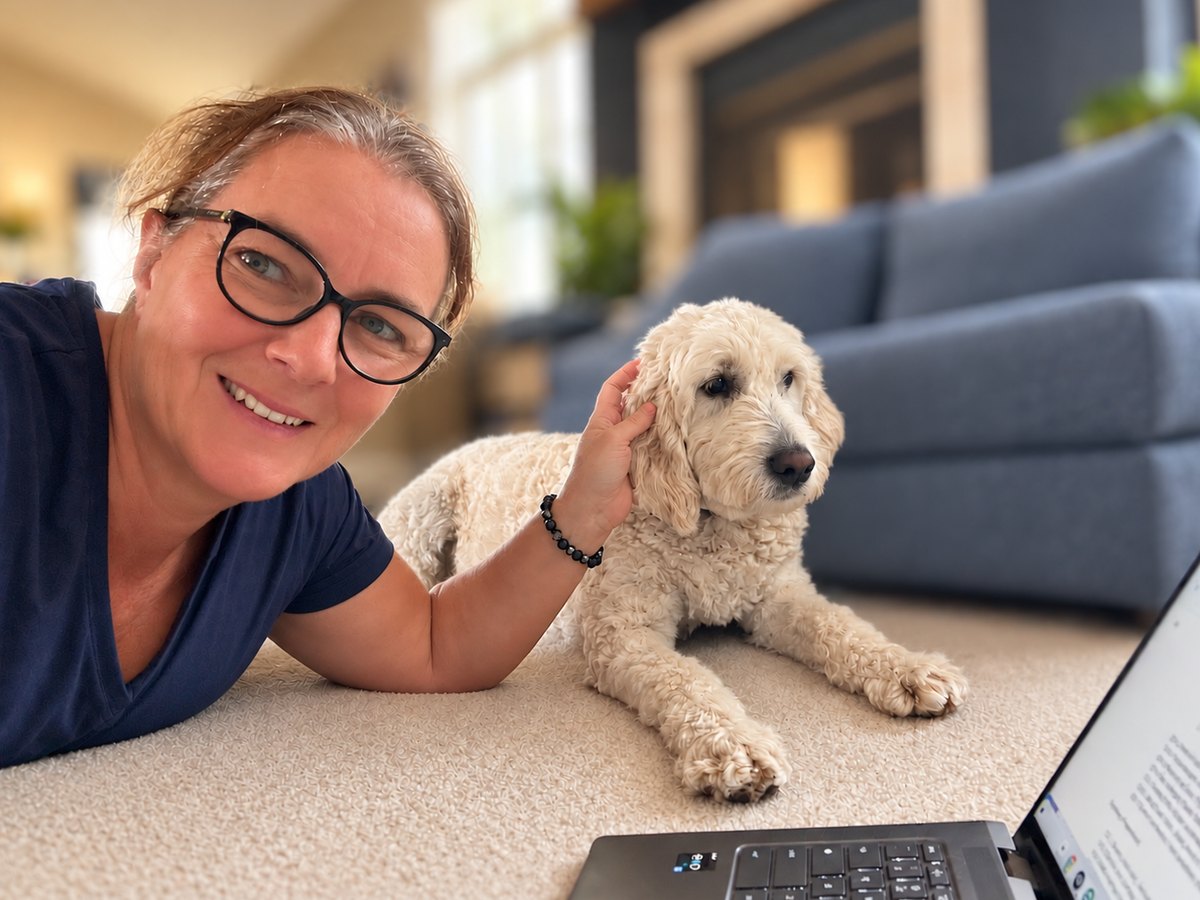 Agnès Déglon-Fischer writing at home, her goldendoodle beside her