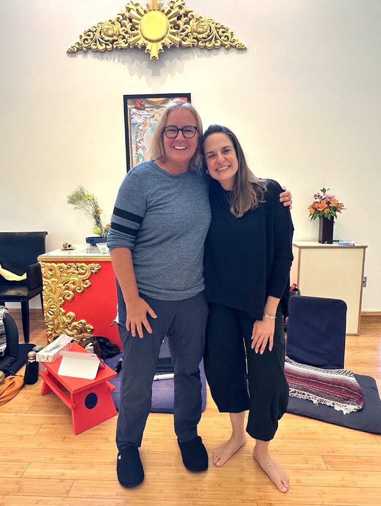 Agnès and Kelly Notaras, arms around each other, in the meeting room